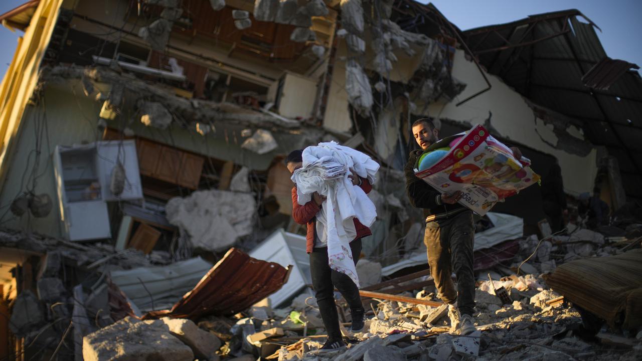 Des résidents quittent les décombres de leur logement à Samandag, dans le Sud de la Turquie. [AP/Keystone - Francisco Seco]