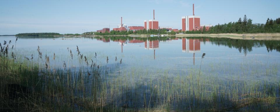 Située dans une réserve naturelle sur les rives de la Mer Baltique, les trois tours de la centrale d'Olkiluoto ont été peintes en rouge pour mieux s'insérer dans le paysage finlandais. Mai 2023. [RTS - Sophie Iselin]