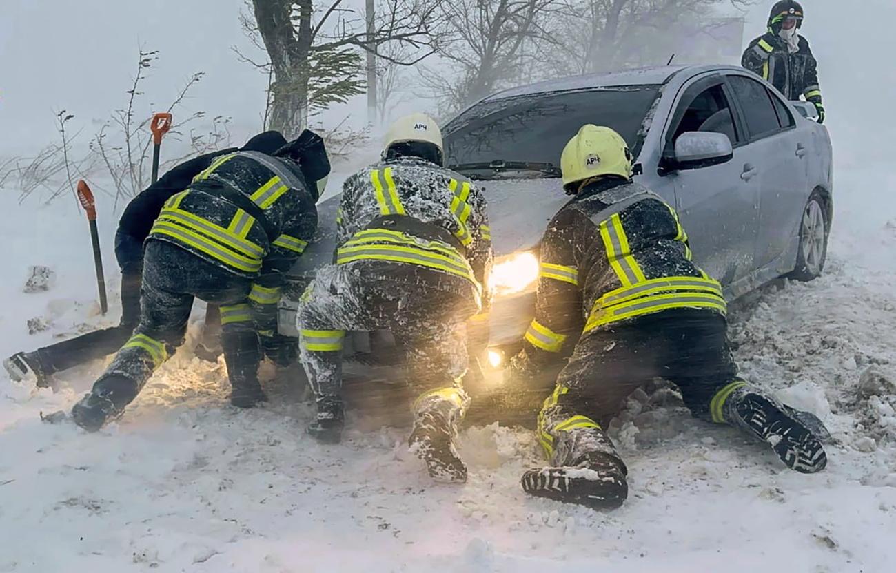 Des secouristes ukrainiens tentent d'extraire une voiture prise dans la neige dans la région d'Odessa. [Reuters - Service d'urgence ukrainien]