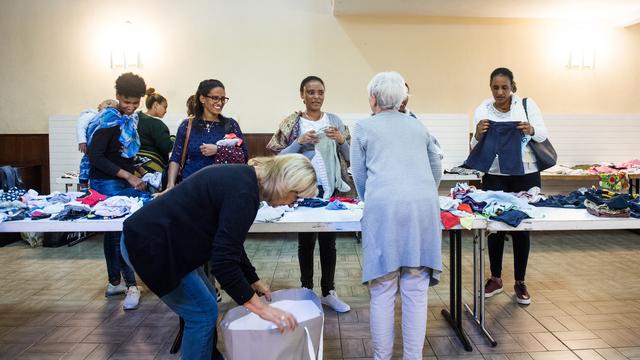 Distribution de vêtements d'occasion à des migrants à Bodio (TI). [Keystone - Alessandro Crinari]