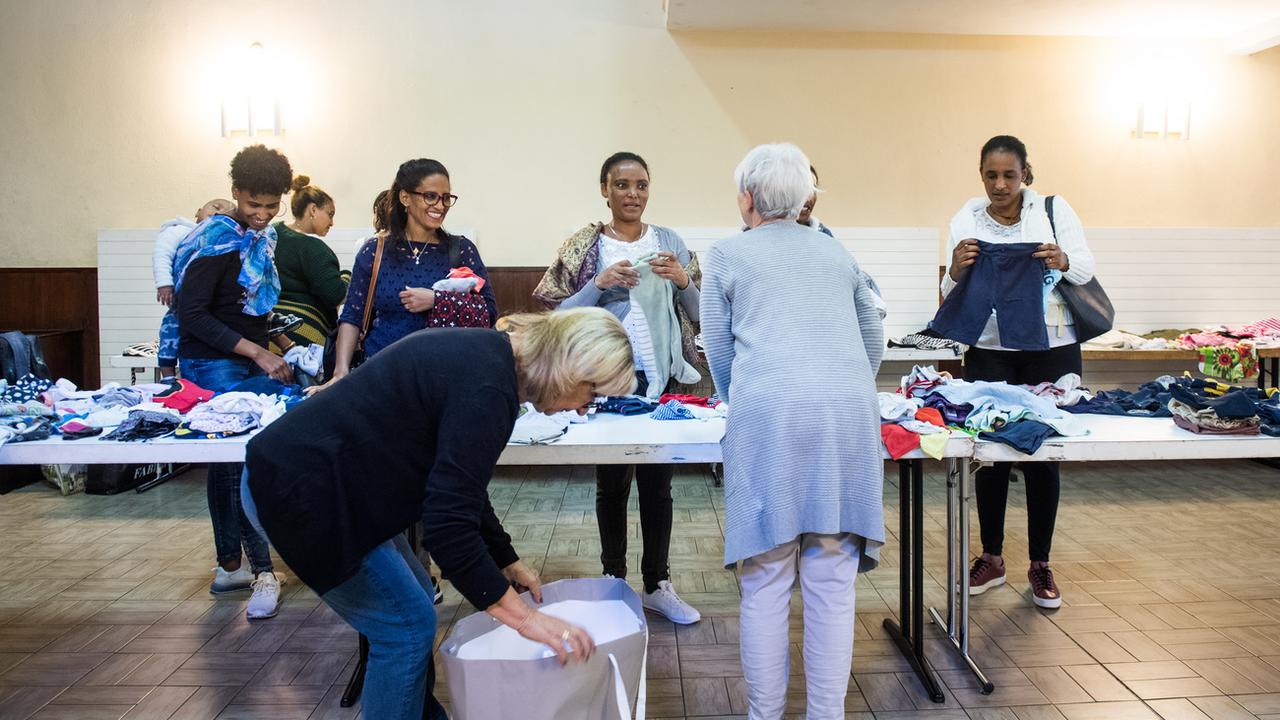 Distribution de vêtements d'occasion à des migrants à Bodio (TI). [Keystone - Alessandro Crinari]