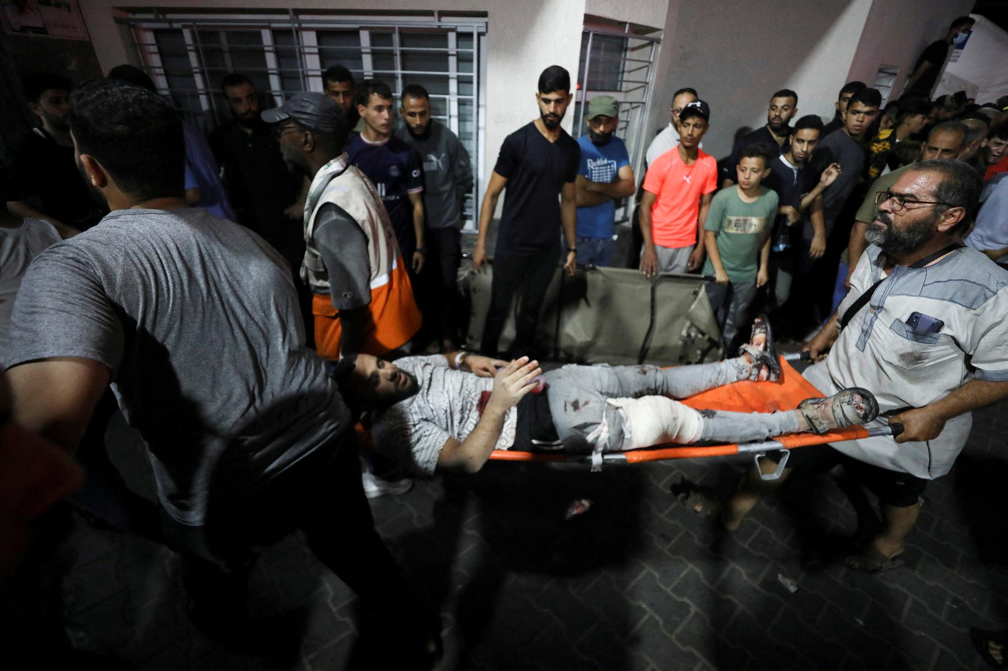 Une personne blessée est assistée à l'hôpital Shifa après qu'une frappe aérienne israélienne a frappé l'hôpital Al-Ahli voisin, le 17 octobre 2023. [Reuters - Mohammed Al-Masri]