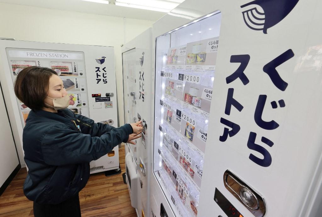 Une employée examine l'un des distributeurs de viande de baleine de Kyodo Senpaku à Tokyo, le 6 janvier 2023. [AFP - Toshikazu Sato / Yomiuri]