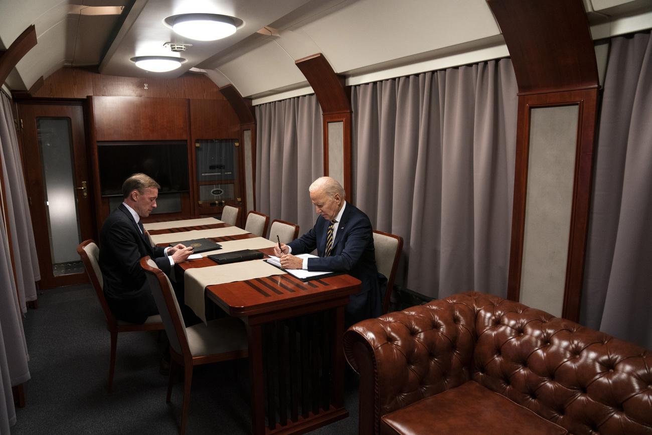 Joe Biden et Evan Vuccun, photographe à l'agence de presse américaine Associated Press, dans un wagon les emmenant à Kiev le 20 février 2023. [Evan Vucci - Keystone]