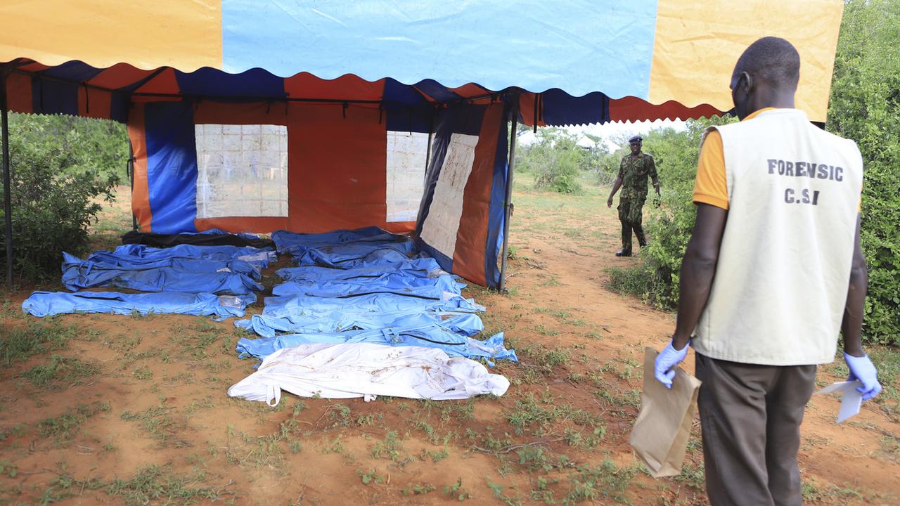 Des sacs de corps contenant des victimes d'un culte christique sont vus lors de l'exhumation d'une forêt à Shakahola, dans la banlieue de la ville de Malindi, sur la côte kenyane, mardi 25 avril 2023. [Keystone - AP photo]