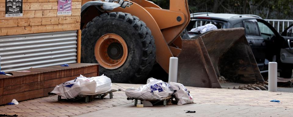 Les cadavres de deux personnes sur des civières dans un quartier résidentiel de Sderot, dans le sud d'Israël, le 8 octobre 2023. [reuters - Ronen Zvulun]