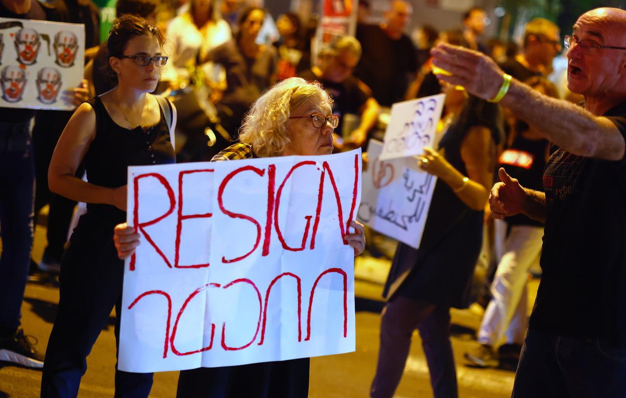 Des gens brandissent des pancartes lors d’un rassemblement appelant à la démission du Premier ministre israélien Netanyahu, à Tel Aviv, Israël, le 28 octobre 2023. [keystone - Hannibal Hanschke]