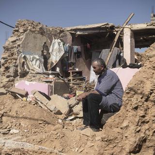 Un homme sur les ruines de sa maison à Amizmiz, près de Marrakech. [Keystone/AP - Mosa'ab Elshamy]
