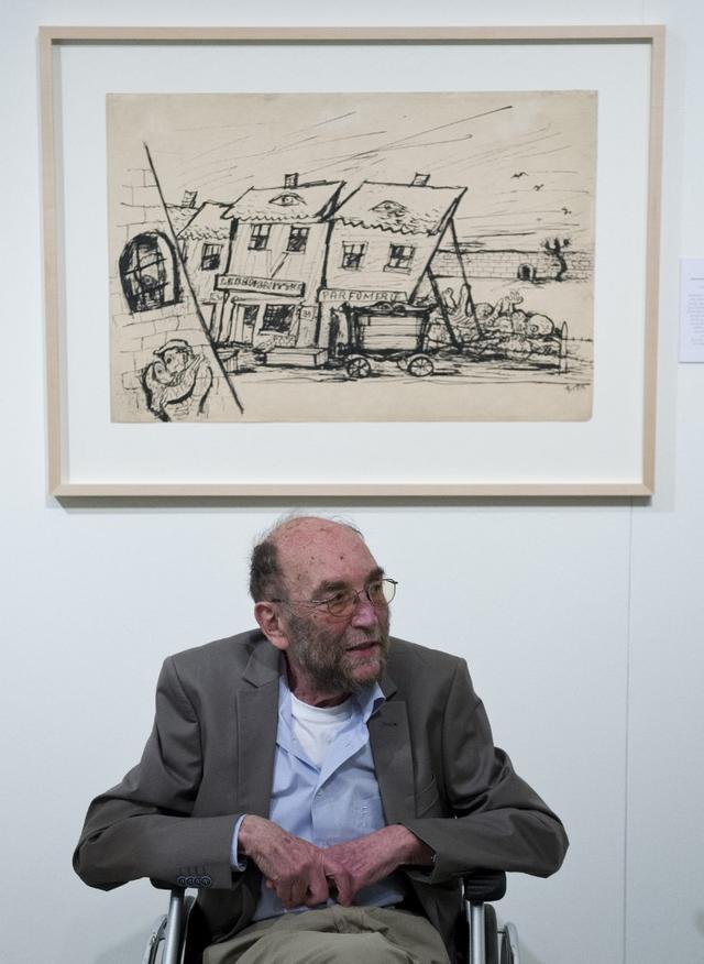 Thomas Fritta pose sous un dessin de son père en 2013. [afp - John MacDougall]