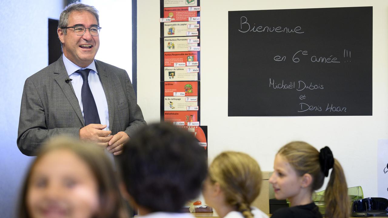Frédéric Borloz parle à des élèves de 6P le jour de la rentrée scolaire des écoliers vaudois le lundi 22 août 2022 à Lausanne. [Keystone - Laurent Gillieron]