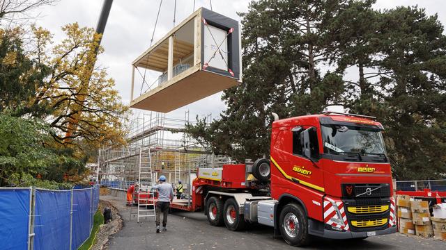 Des ouvriers posent l'un des pavillons scolaires de l'école Trembley, le lundi 14 novembre 2022. [Keystone - Salvatore Di Nolfi]