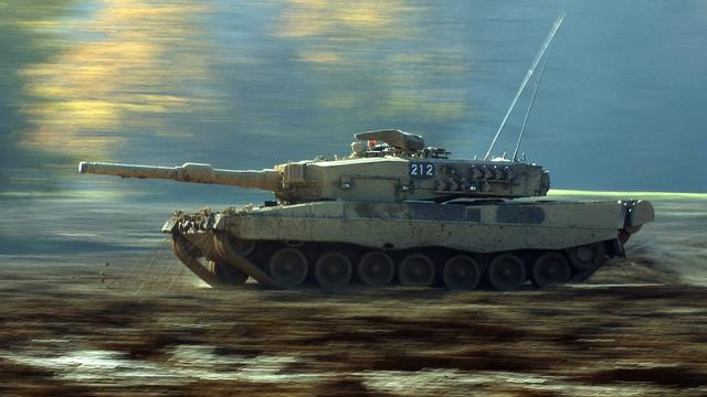 Un char Leopard II suisse roule dans la boue du terrain d'exercice de la place d'armes de Bure, dans le Jura, le jeudi 6 novembre 2003. [Keystone - Gaetan Bally]