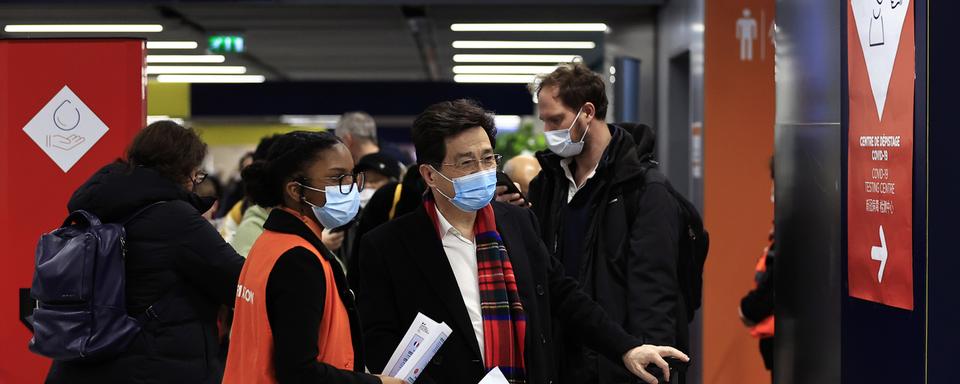 Des passagers chinois attendent de se faire tester au Covid à leur arrivée à l'aéroport Charles de Gaulle, à Paris. [AP Photo/Keystone - Aurelien Morissard]