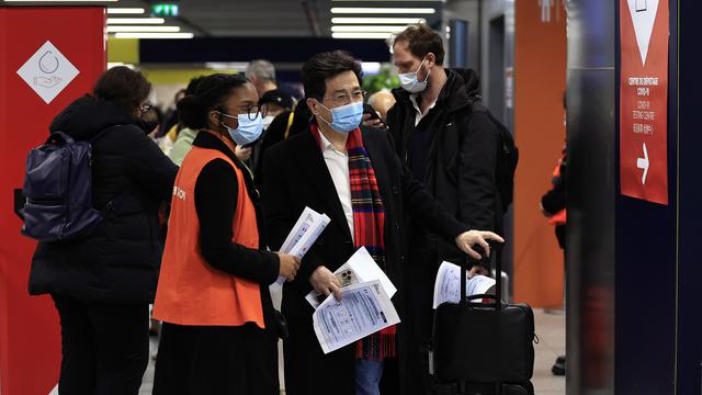 Des passagers chinois attendent de se faire tester au Covid à leur arrivée à l'aéroport Charles de Gaulle, à Paris. [AP Photo/Keystone - Aurelien Morissard]