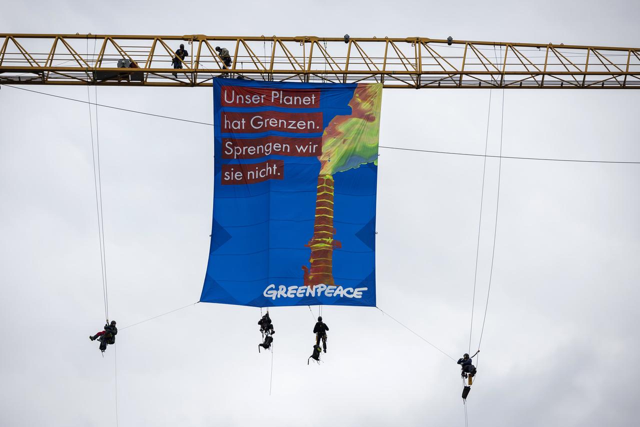 "Notre planète a des limites, ne les faisons pas sauter", peut-on lire sur la banderole de Greenpeace. [Keystone - Peter Klaunzer]