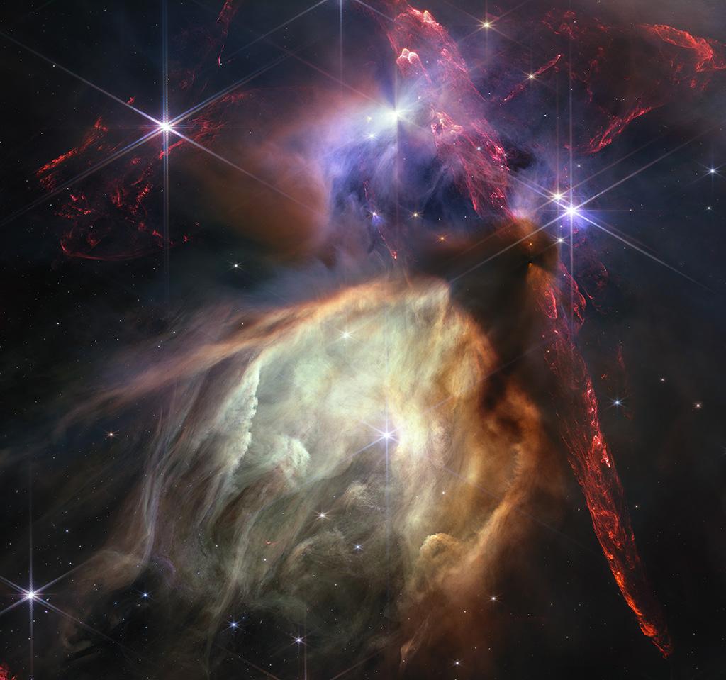 Vu la proximité de Rho Ophiuchi, le JWST a capturé beaucoup de détails de cette formation. Au centre, une cavité géante est creusées grâce à des photons ultraviolets par une seule étoile, S1, plus massive que le Soleil. La couleur jaune-orange provient de minuscules grains de suie appelés hydrocarbures aromatiques polycycliques. La grande bande verticale rouge est un écoulement protostellaire: des jets puissants de matière se produisant aux premiers stades de la formation des étoiles. L'ensemble de la structure rougeoie en raison de l'hydrogène moléculaire énergisé lorsque la matière des jets entre en collision avec le gaz interstellaire. [NASA, ESA, CSA - Greg Bacon (STScI)]