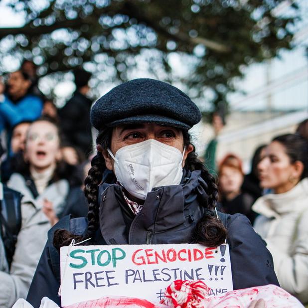 Une activiste tient le cadavre d'un faux bébé avec une pancarte sur laquelle on peut lire "Stop genocide - free palestine" lors d'une manifestation de solidarité avec les Palestiniens à Berlin, en octobre 2023. [Keystone - EPA/ Clemens Bilan]