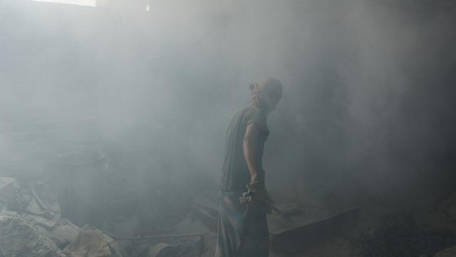 Un travailleur broie du plomb sans véritable masque de protection dans une atmosphère saturée de poussière au Bangladesh, en 2013. [AFP - Jonathan Raa/Nurphoto]