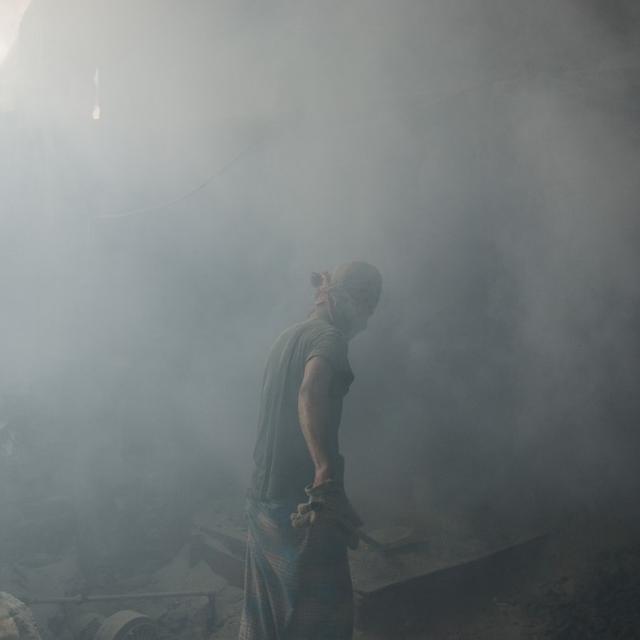 Un travailleur broie du plomb sans véritable masque de protection dans une atmosphère saturée de poussière au Bangladesh, en 2013. [AFP - Jonathan Raa/Nurphoto]