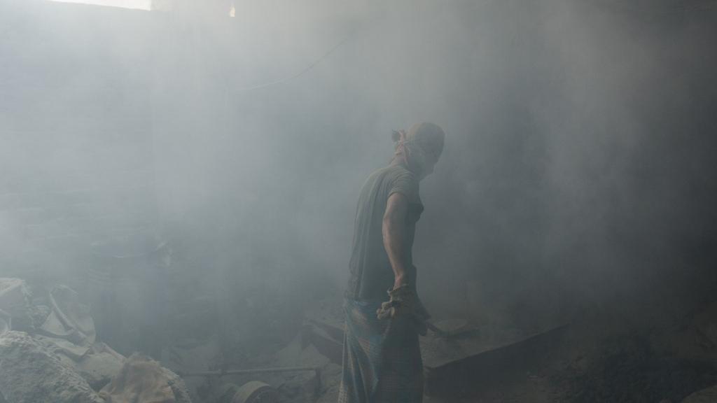 Un travailleur broie du plomb sans véritable masque de protection dans une atmosphère saturée de poussière au Bangladesh, en 2013. [AFP - Jonathan Raa/Nurphoto]