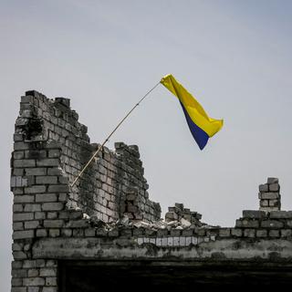 Un drapeau ukrainien sur les ruines d'un village récemment repris par les forces ukrainiennes. [Reuters - Oleksandr Ratushniak]