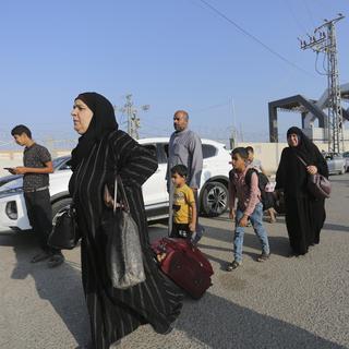 Des personnes palestiniennes binationales et étrangères ont pu quitter Gaza par l'Égypte. [Keystone/AP Photo - Hatem Ali]