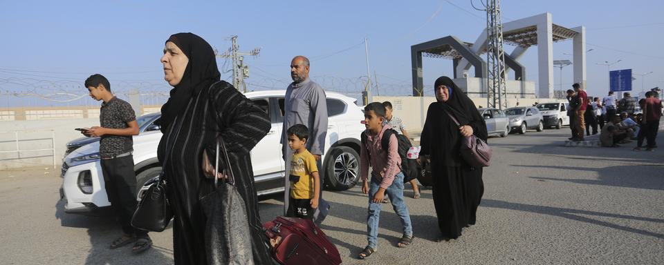 Des personnes palestiniennes binationales et étrangères ont pu quitter Gaza par l'Égypte. [Keystone/AP Photo - Hatem Ali]