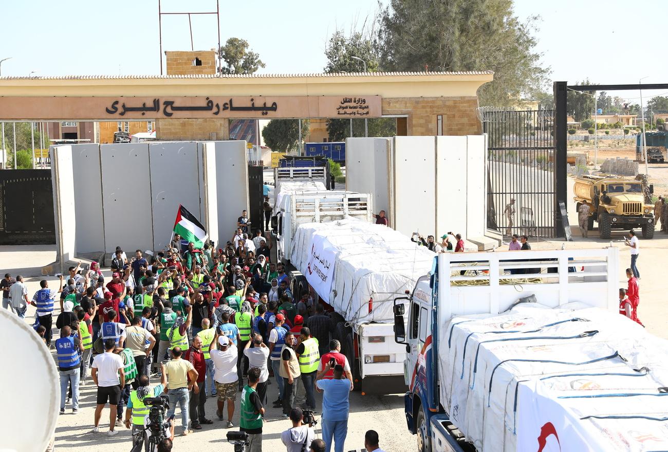 Des camions d'aide humanitaire entrent dans la bande de Gaza au 15e jour de guerre entre Israël et le Hamas. [Keystone - EPA/Khaled Elfiqi]