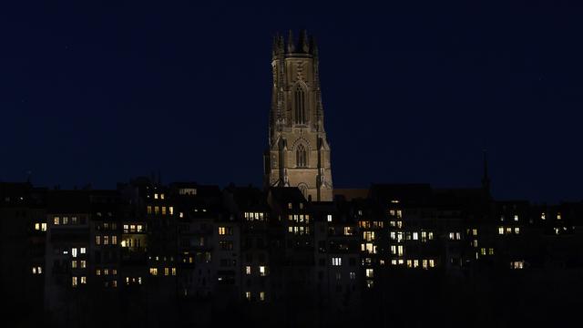 La cathédrale Saint-Nicolas à Fribourg de nuit. [Keystone - Anthony Anex]