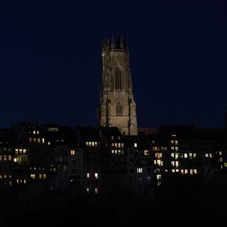 La cathédrale Saint-Nicolas à Fribourg de nuit. [Keystone - Anthony Anex]