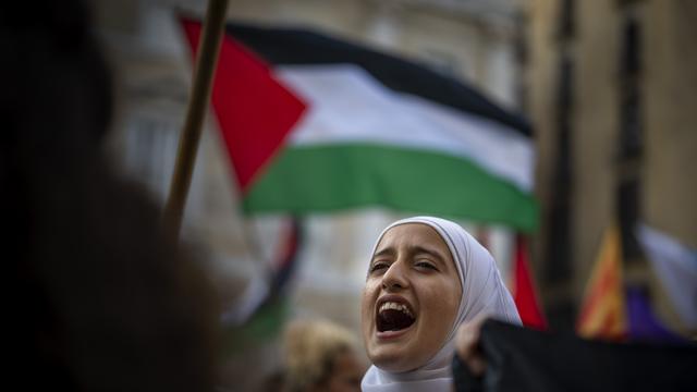 Une manifestante lors d'une marche solidaire avec la Palestine contre les attaques israéliennes sur Gaza en Espagne, 2023. [Keystone/AP Photo - Emilio Morenatti]