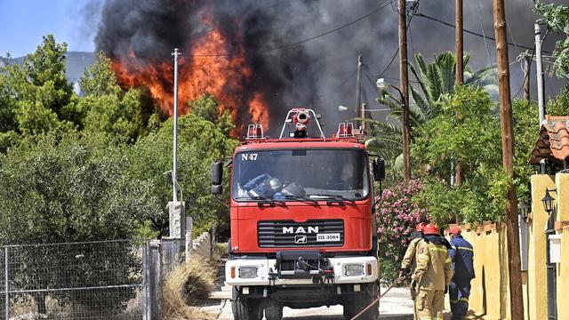 Des pompiers luttant contre les flammes à Loutraki, en Grèce. [Keystone - EPA/Vassilis Psomas]