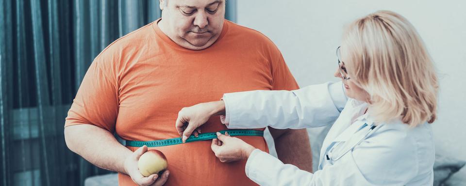 Une médecin mesure le tour de taille d'un patient en surpoids. [Depositphotos - vadimphoto1@gmail.com]