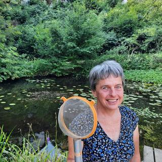 Sylvie Barbalat, écrivaine et docteure en entomologie, devant un étang du Jardin botanique de Neuchâtel. [RTS - Sarah Dirren]