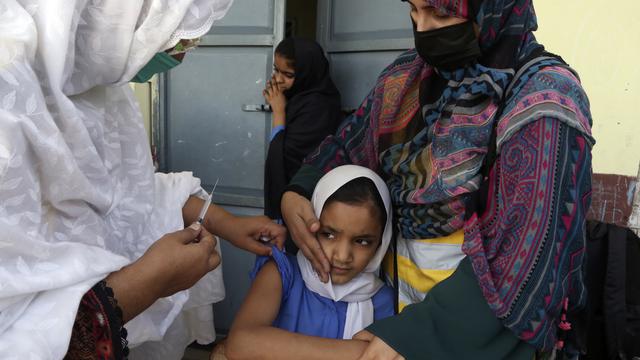 Une écolière reçoit une dose de vaccin contre la typhoïde à Peshawar au Pakistan. [Muhammad Sajjad]
