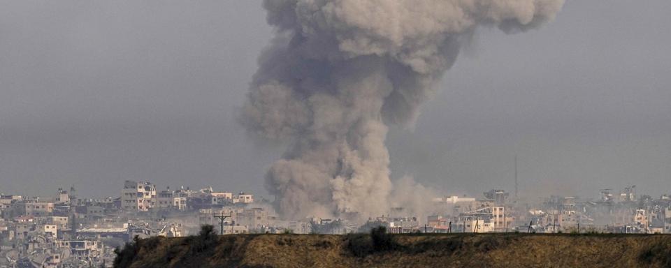 De la fumée s'élève après un bombardement israélien dans la bande de Gaza. [Keystone - Ohad Zwigenberg]