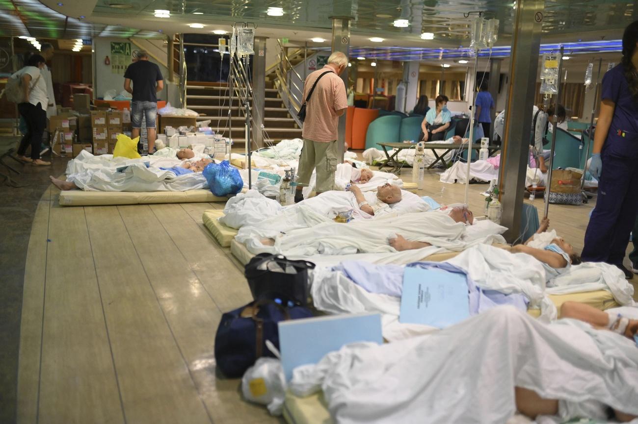 Des patients de l'hôpital d'Alexandropolis ont dû être évacués à bord d'un ferry alors que les flammes menaçaient l'établissement. [Keystone/e-evros.gr via AP]
