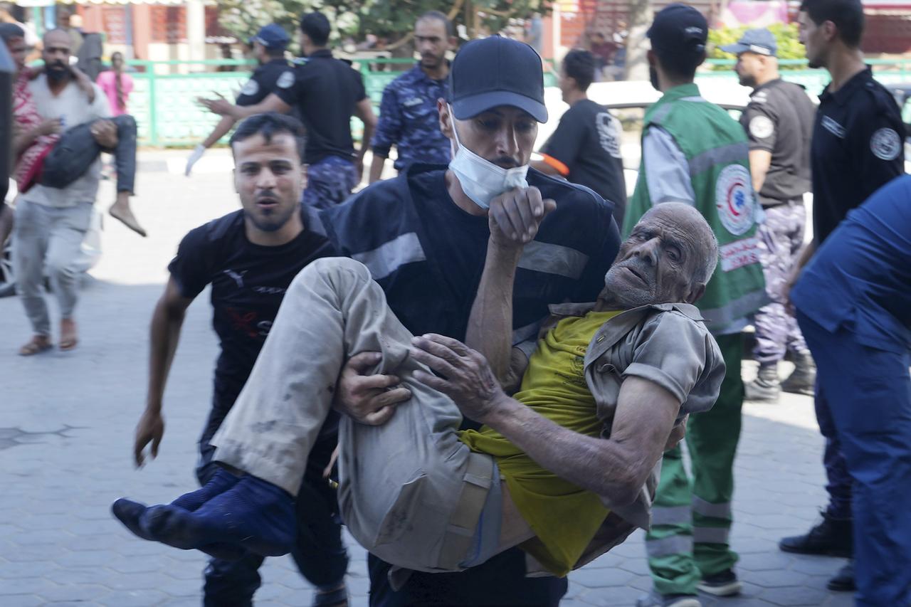 Un Palestinien blessé dans la bande de Gaza est acheminé à l'hôpital al-Aqsa à Deir el-Balah City. [Keystone/AP - Adel Hana]