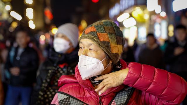 Une femme porte un masque de protection à Pékin, en Chine, le 14 novembre 2023. Les autorités sanitaires chinoises mettent en garde contre une augmentation des maladies respiratoires telles que la pneumonie à mycoplasme, le Covid-19 et la grippe à l'approche de l'hiver. [Keystone - EPA/MARK R. CRISTINO]