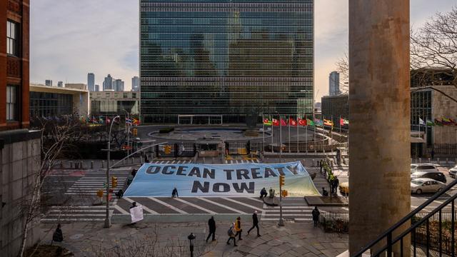 Des militants de Greenpeace déploient une banderole devant le siège des Nations unies pendant les négociations en cours à l'ONU sur un traité de protection de la haute mer, à New York, le 27 février 2023. [AFP - Ed Jones]