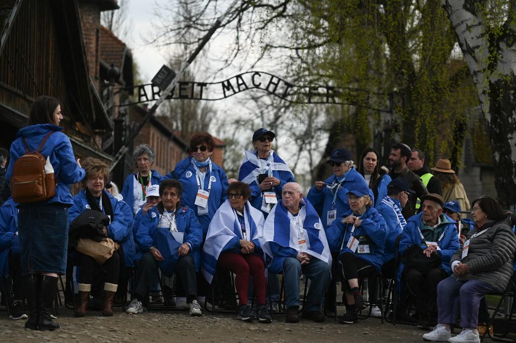 Des survivants de la Shoah et des participants avant le début de la Marche des Vivants sur le site de l'ancien camp de concentration et d'extermination nazi d'Auschwitz-Birkenau à Oswiecim, le 18 avril 2023. [AFP - Artur Widak / Anadolu Agency]