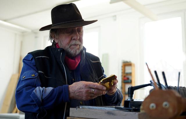 Gunter Demnig en train de réaliser une Stolperstein dans son atelier d'Alsfeld. Allemagne, le 28 février 2023. [Reuters - Timm Reichert]