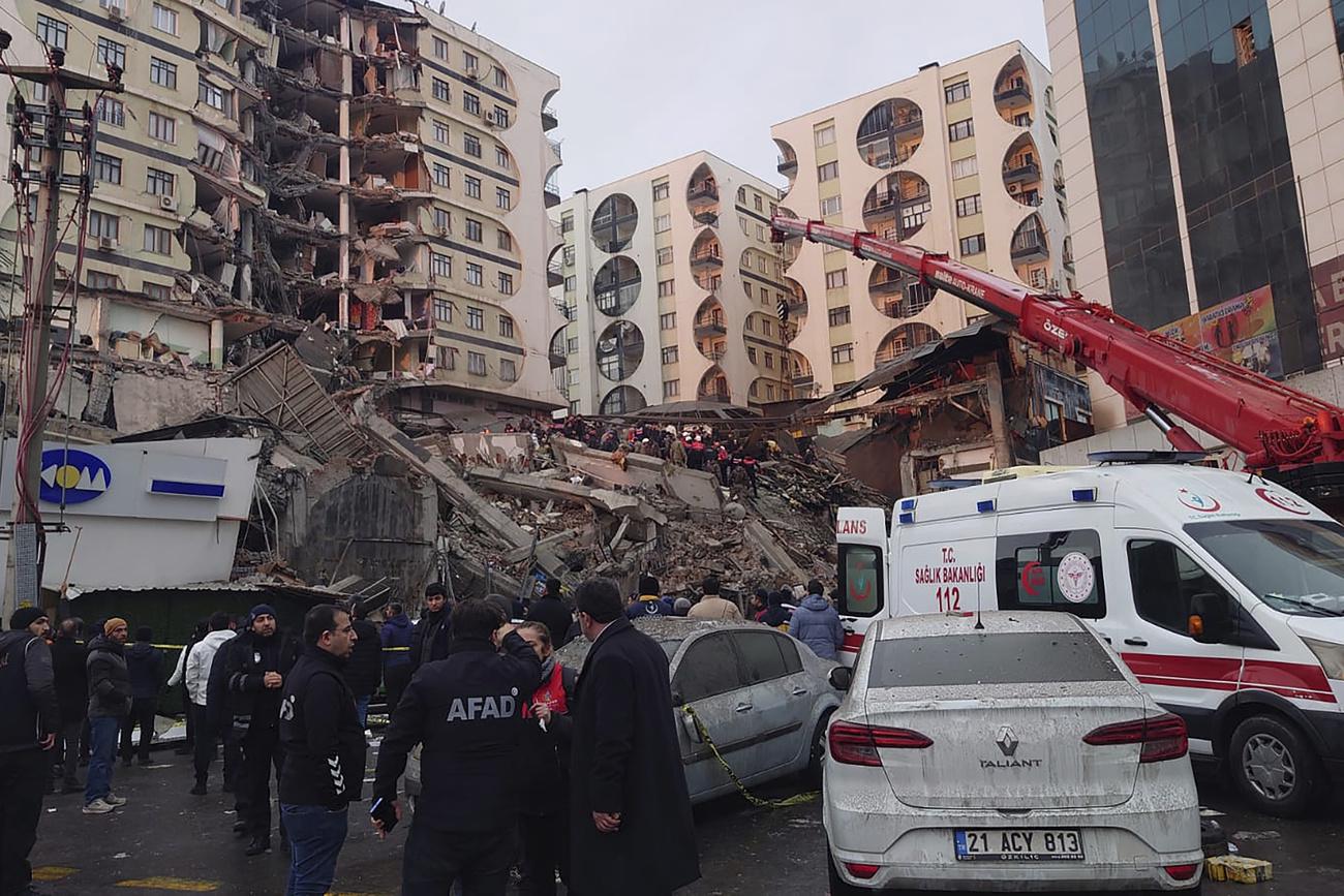 De nombreux immeubles se sont effondrés à cause du séisme, comme ici à Diyarbakir en Turquie. [Keystone - AP Photo/Mahmut Bozarsan]