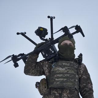 Un soldat ukrainien tranporte un drone près d'Avdiivka, dans la région de Donetsk, le 17 février 2023. [Keystone - AP Photo/Libkos]