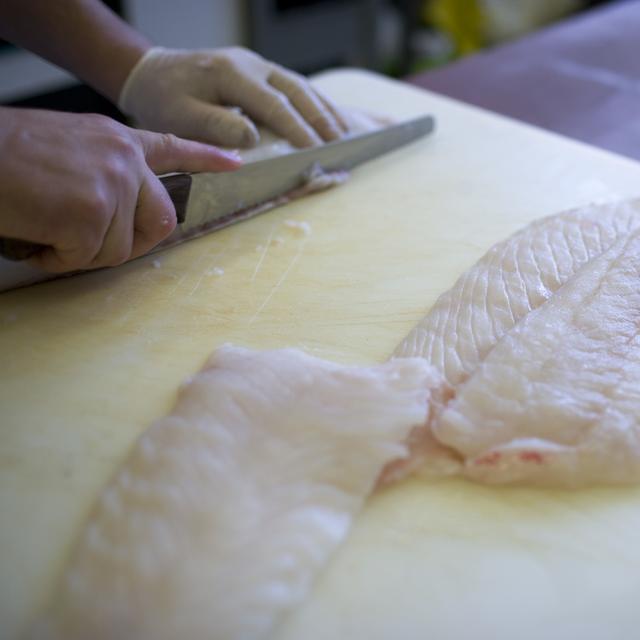 Préparation d'un filet de poisson dans un restaurant suisse en 2009. [Keystone - Gaetan Bally]