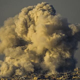 De la fumée s'élève après un bombardement israélien dans la bande de Gaza, vue depuis le sud d'Israël, le 16 décembre 2023. [KEYSTONE - ARIEL SCHALIT]