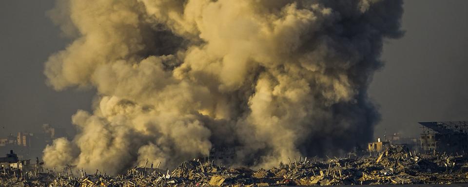 De la fumée s'élève après un bombardement israélien dans la bande de Gaza, vue depuis le sud d'Israël, le 16 décembre 2023. [KEYSTONE - ARIEL SCHALIT]