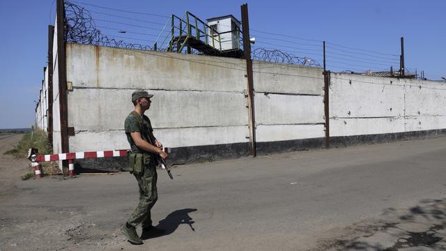 Un soldat près d'une prison dans une région ukrainienne contrôlée par la Russie. [Keystone/AP Photo - File]