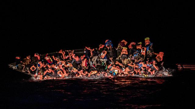Des dizaines de migrants tombent à l'eau alors qu'ils luttent pour s'accrocher au côté d'un bateau en train de chavirer au large de la Tunisie (image d'archive). [Keystone/AP - Valeria Ferraro]