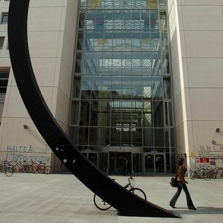 Un personne passe devant le bâtiment de l'UNI Mail Université de Genève. [Keystone - Martial Trezzini]